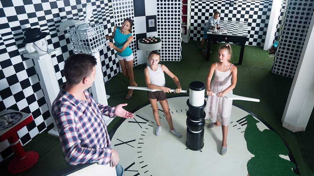 Семья с детьми ищет решение загадки в квесте оформленном шахматной доской