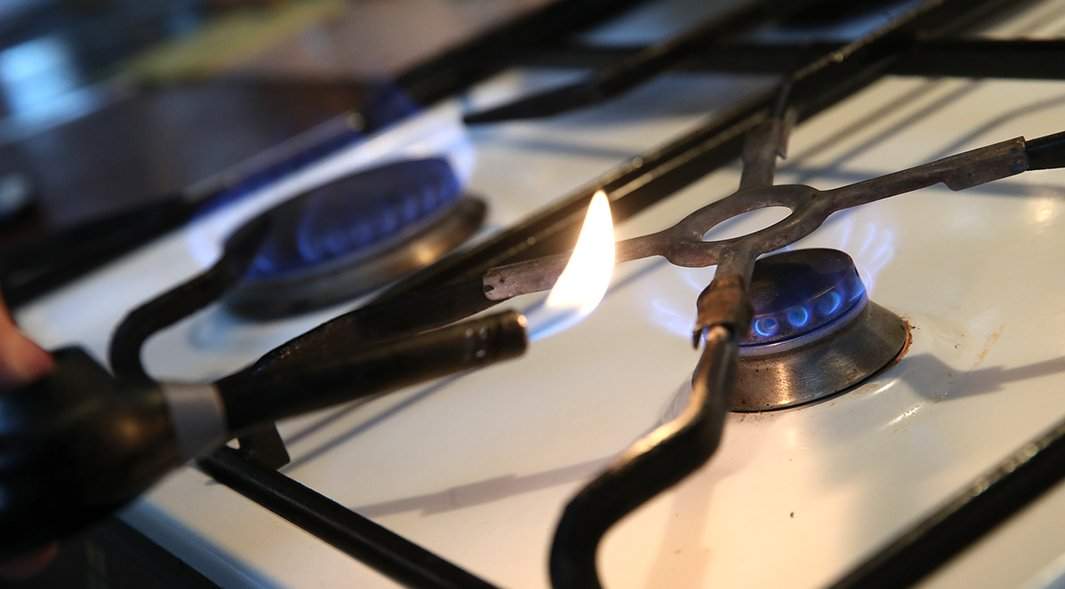 Человек пытается зажечь газовую плиту