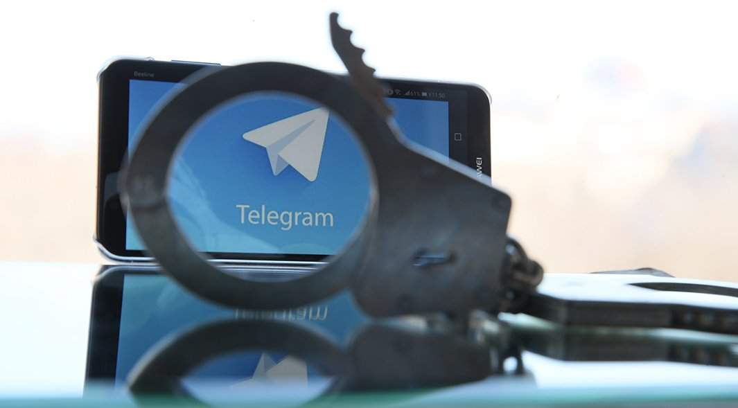 телефон с эмблемой телеграм и наручники