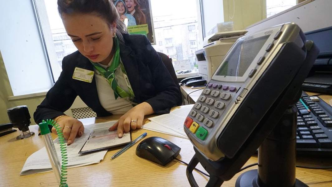 Сотрудница банка во время работы с клиентом