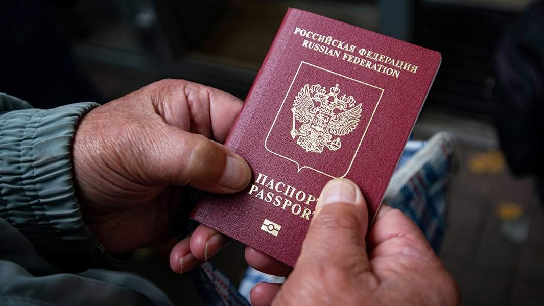 Мужчина держит в руках свой паспорт 