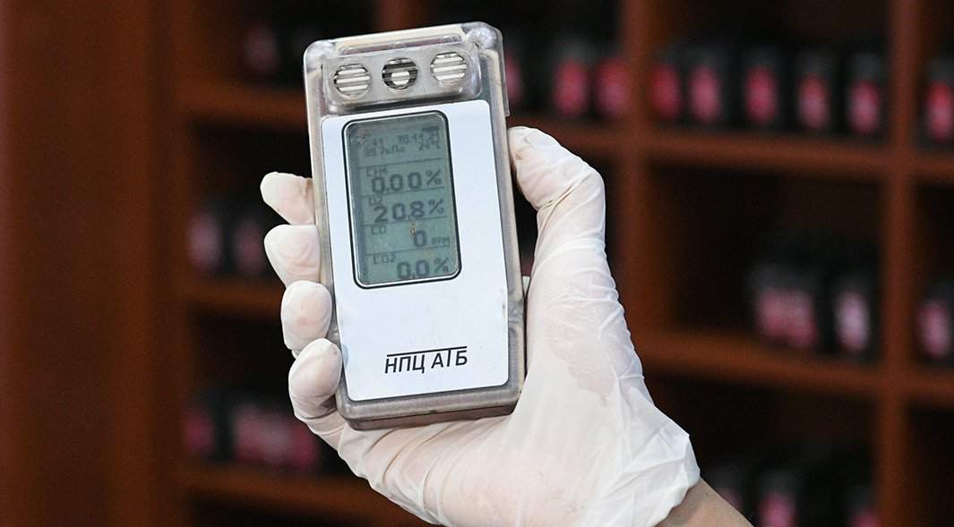 Женщина демонстрирует работоспособность портативного переносного газоанализатора