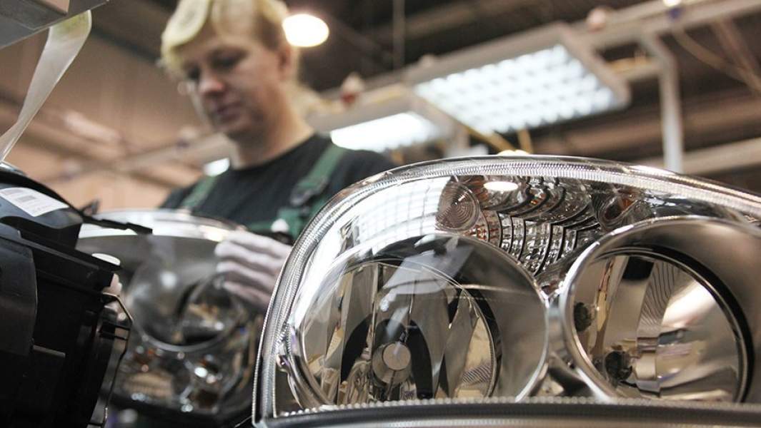 Работница сборочного цеха на заводе по производству автомобильных фар