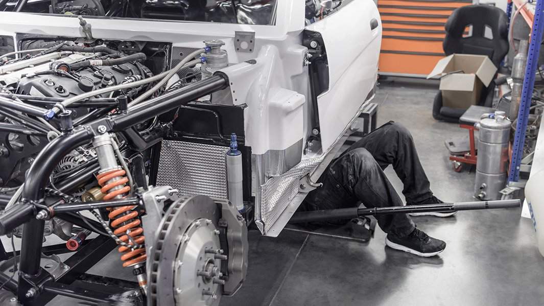 Инженер работает под авто