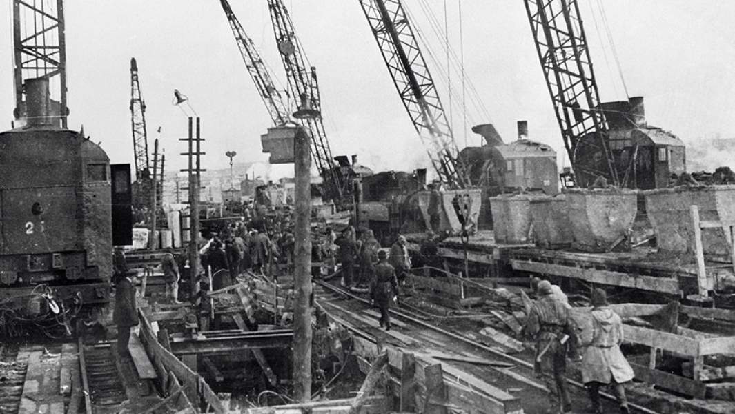 Строители Днепрогэса укладывают бетон на плотине с помощью железнодорожных кранов