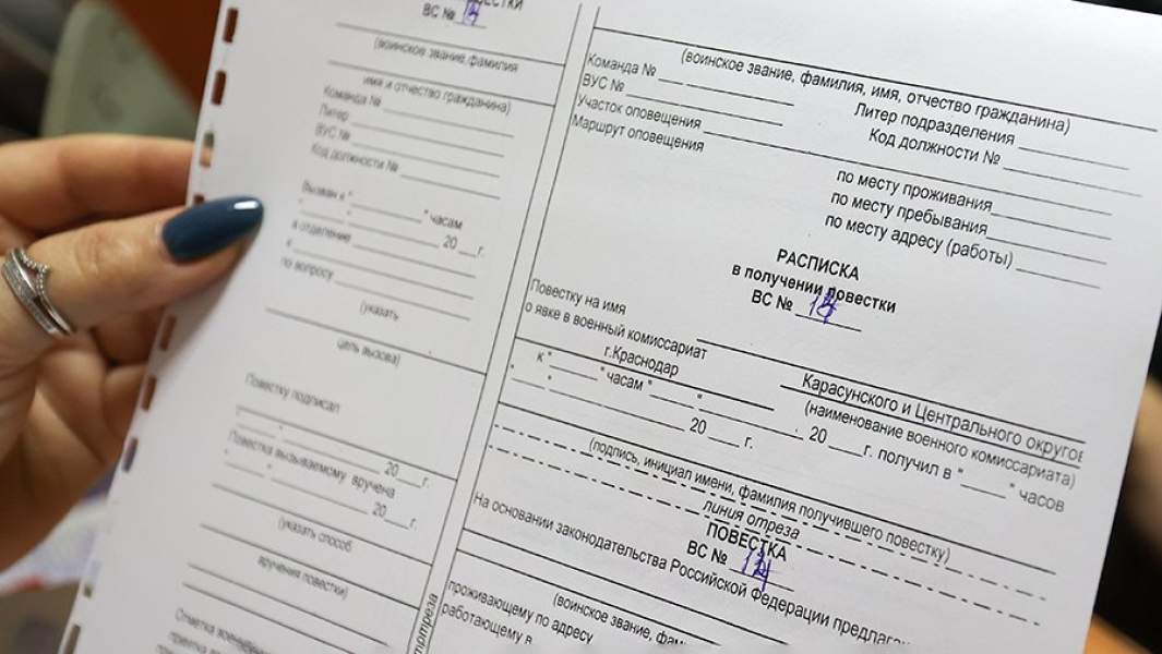 Сотрудница военного комиссариата Краснодара демонстрирует повестку о явке в военкомат призванного на воинскую службу