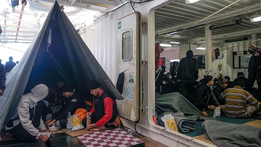 Мигранты едят на палубе спасательного корабля неправительственной организации Ocean Viking