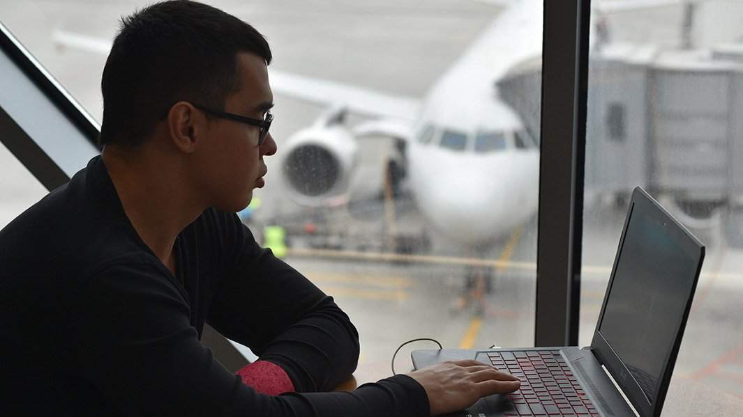 Мужчина за ноутбуком в аэропорту