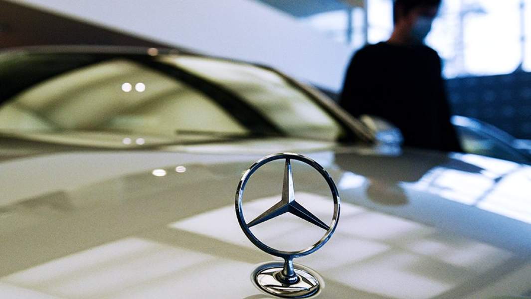 Менеджер демонстрирует покупателям автомобиль в автосалоне по продаже подержанных авто