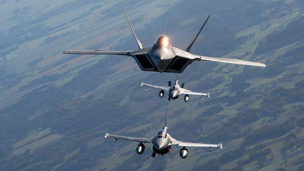 Força Aérea dos EUA F-22 Raptor voando ao lado de dois F-16 poloneses