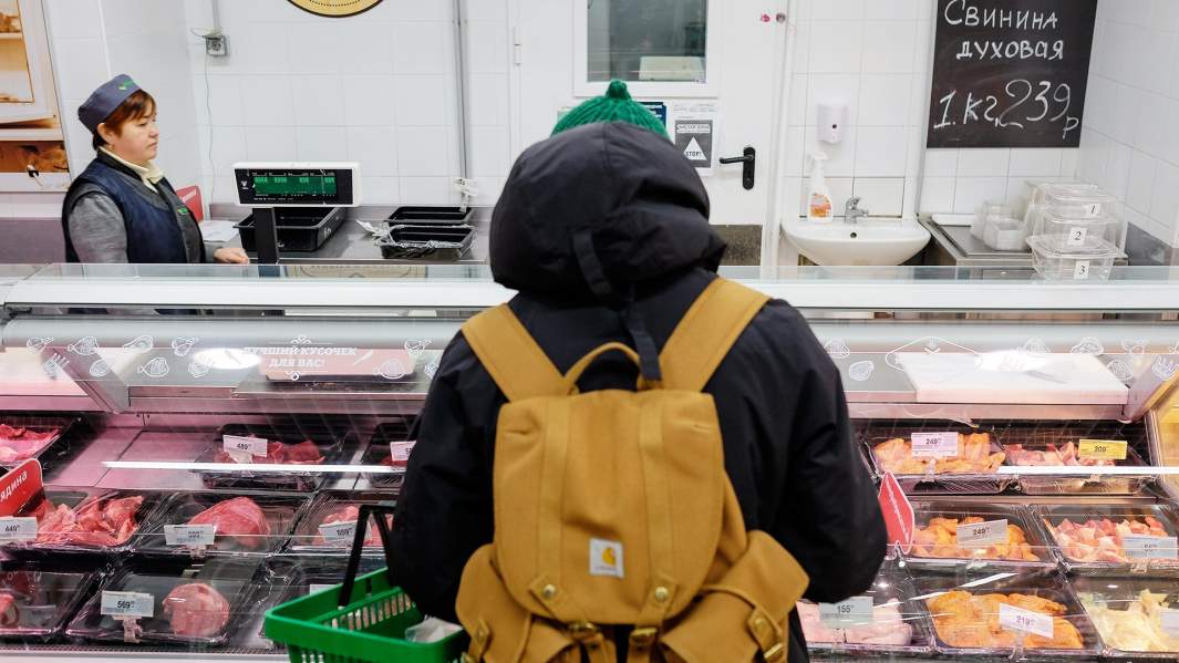 Мужчина перед мясным прилавком