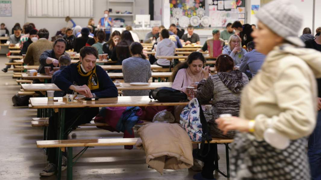 Беженцы из Украины обедают в столовой центра регистрации беженцев в Берлине