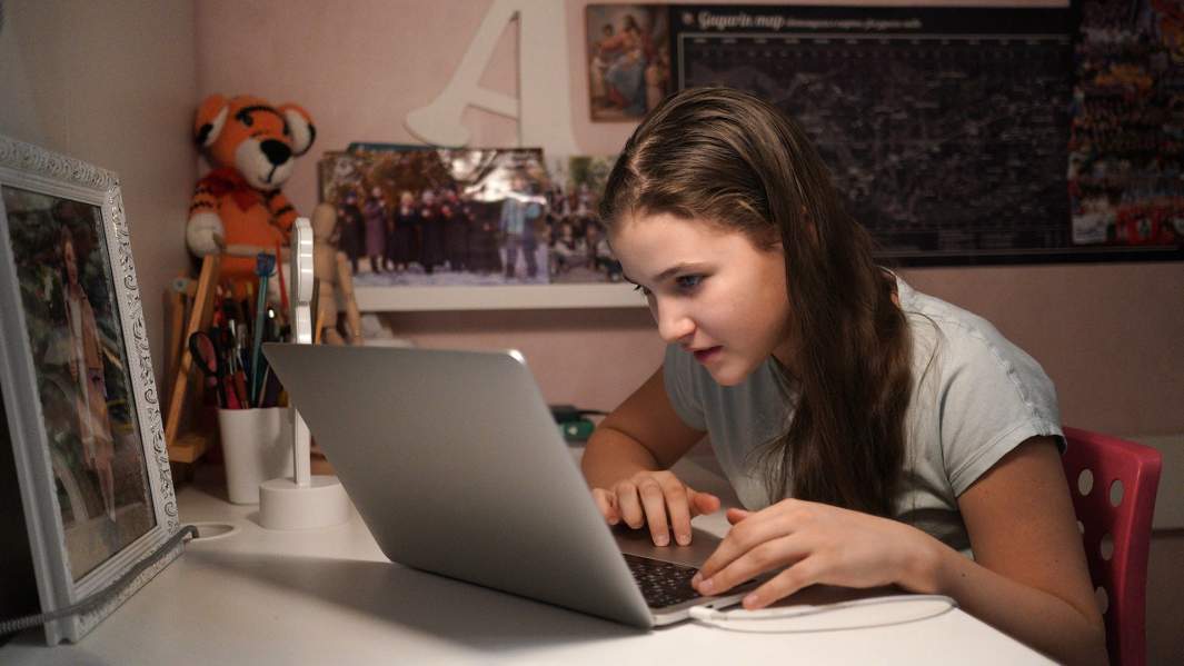 Девочка сидит с ноутбуком в интернете