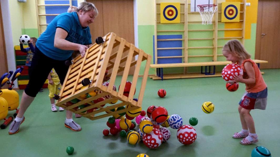 Воспитательница в детском саду играет с ребенком
