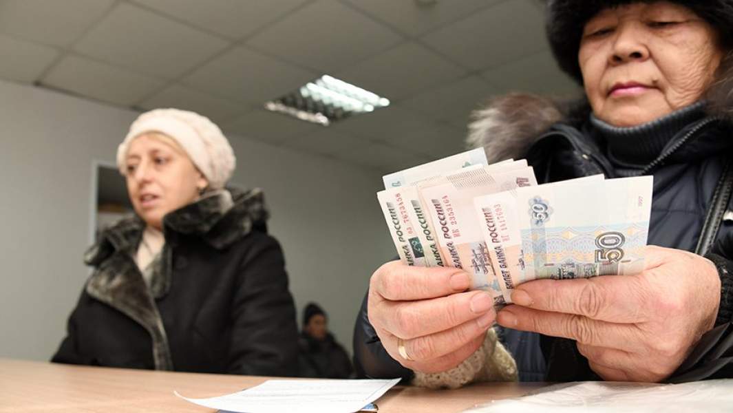 Женщина пересчитывает полученную пенсию