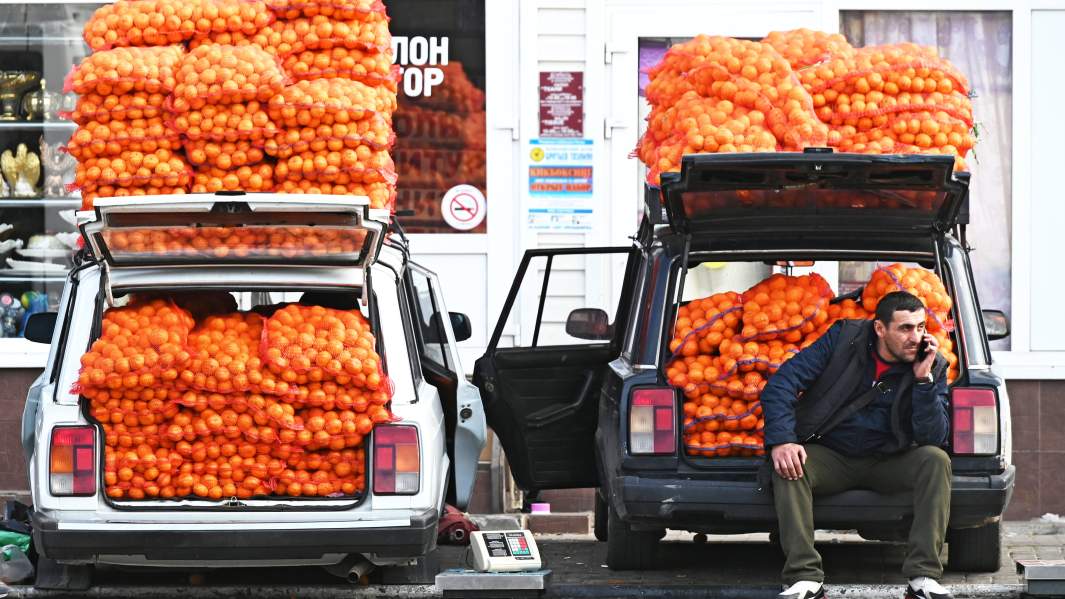 продавец торгует мандаринами из машины