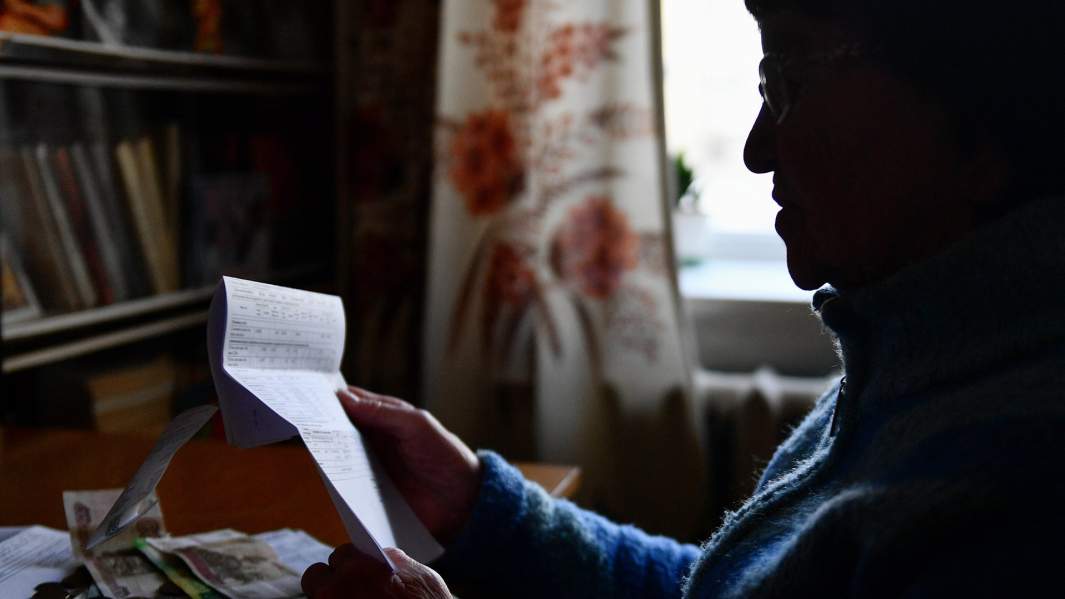 пенсионерка держит квитанцию