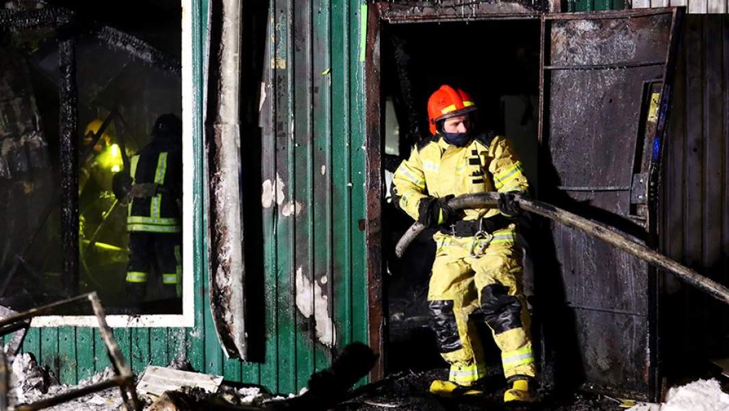 Сотрудники пожарной службы МЧС РФ работают на месте пожара в здании частного дома престарелых на улице Таврическая в Кемерово