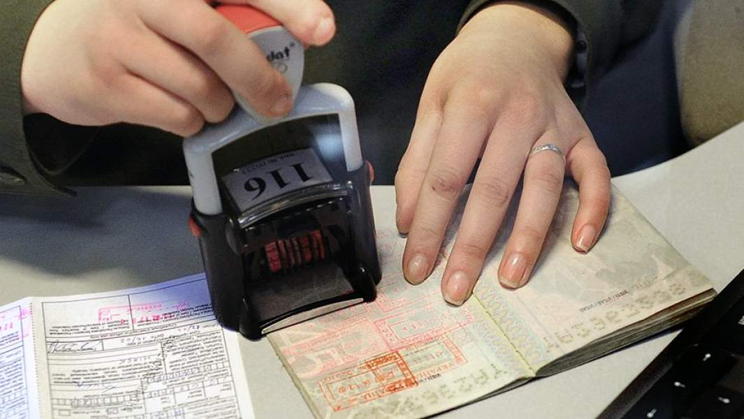 Сотрудник таможенной службы ставит штамп в паспорт