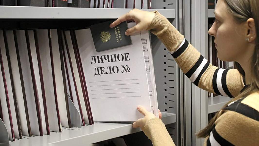 Сотрудница отдела кадров с папкой личного дела и трудовой книжкой