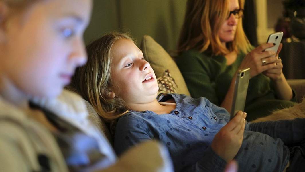 Дети и женщина отдыхают на диване