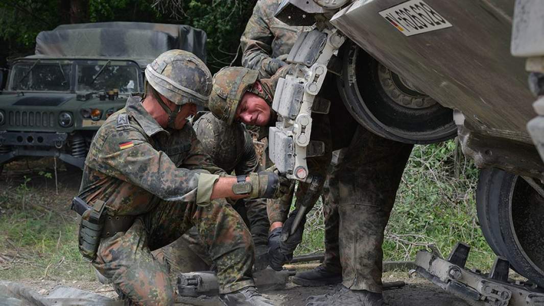 Военнослужащие бундесвера меняют гусеничные траки на танке Leopard 2A6