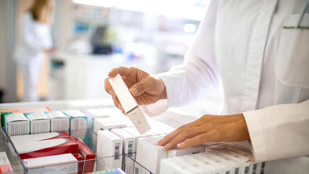 Фармацевт отпускает лекарства в аптеке