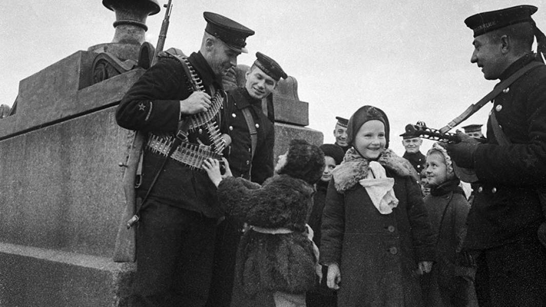 Моряки Балтийского флота общаются с детьми на набережной реки Невы в дни блокады Ленинграда