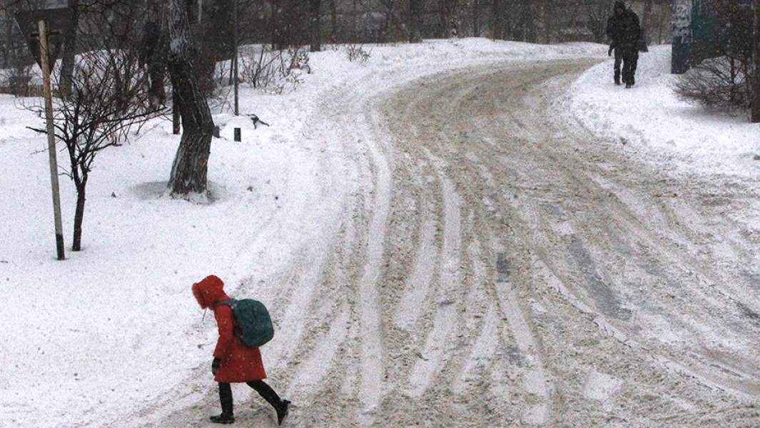 Пешеходы во время снегопада на одной из улиц