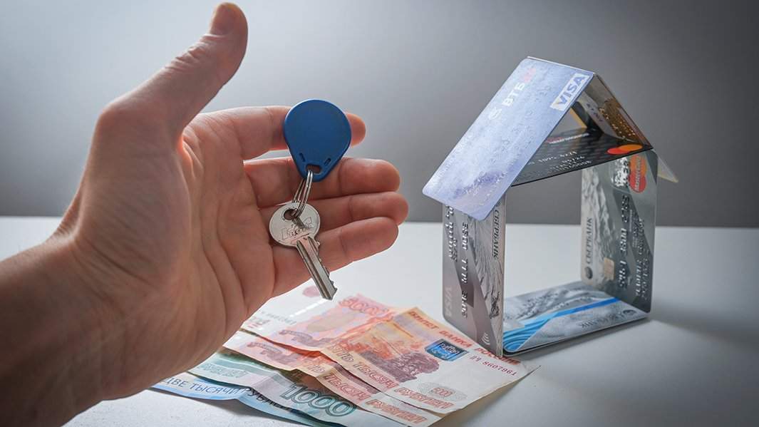 Ключ, деньги и домик, сложенный из банковских карт