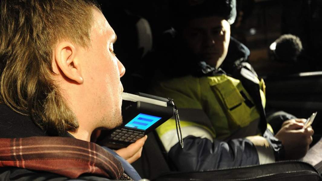 Сотрудник ГИБДД во время проверки водителя автомобиля алкотестером на содержание алкоголя в крови