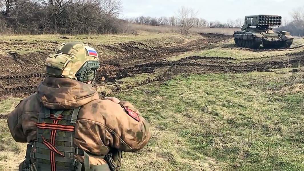 Военнослужащий подразделения радиационной, химической и биологической защиты возле огнеметной системы ТОС-1А в зоне проведения специальной военной операции