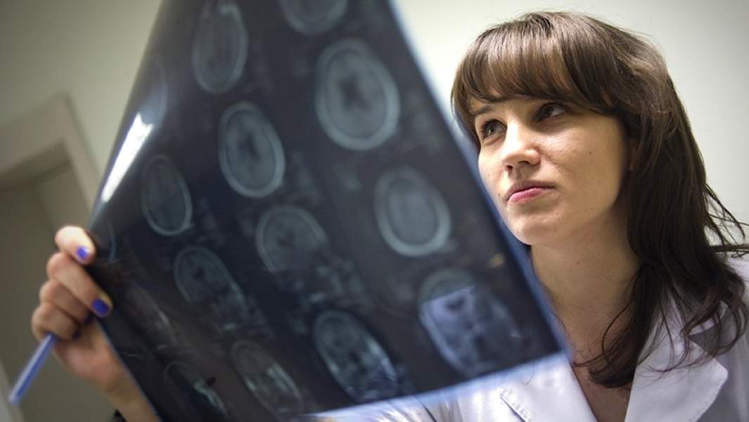 Врач клиники изучает результаты магнитно-резонансной томографии мозга