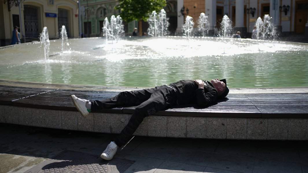 мужчина спит возле фонтана