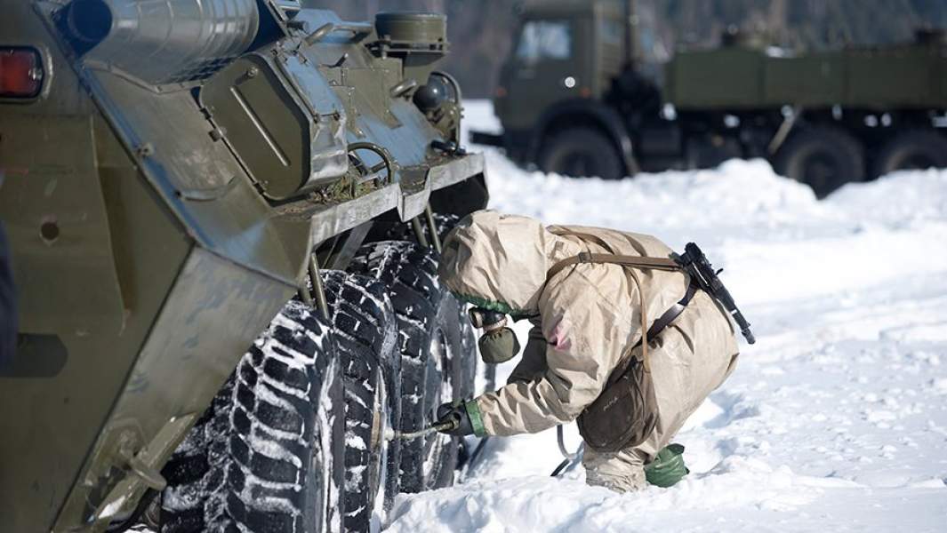 Военнослужащий обрабатывает бронированную машину для химической и радиационной разведки РХМ-4-01 с помощью авторазливочной станции АРС-14КМ во время тактико-специальных занятий подразделений радиационной, химической и биологической защиты ЦВО
