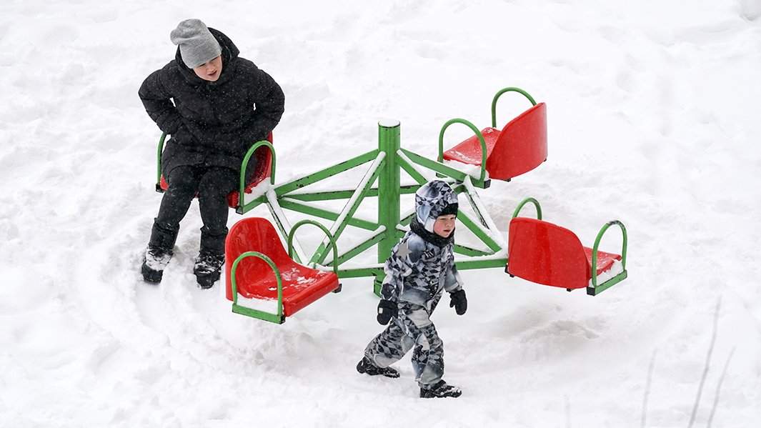 женщина гуляет на детской площадке с ребенком
