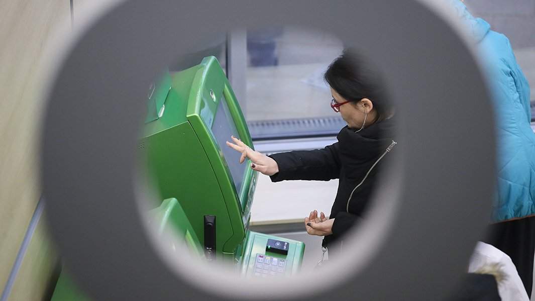 женщина вносит деньги на счет