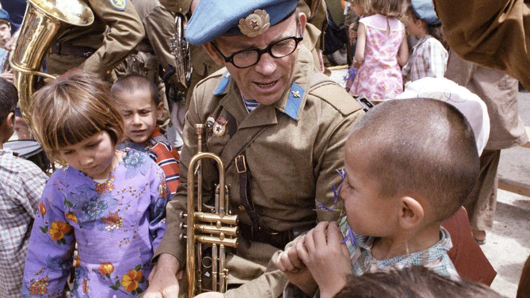 Советский музыкант военного оркестра с афганскими детьми