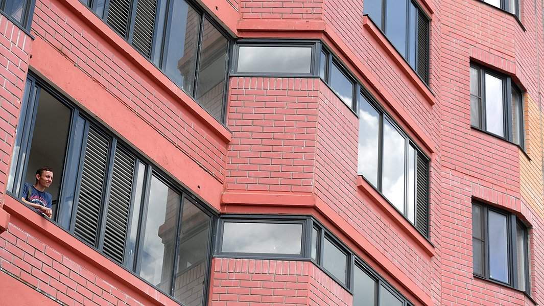 жилец дома смотрит в окно