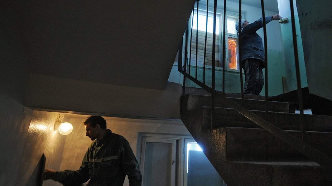 работники красят подъезд