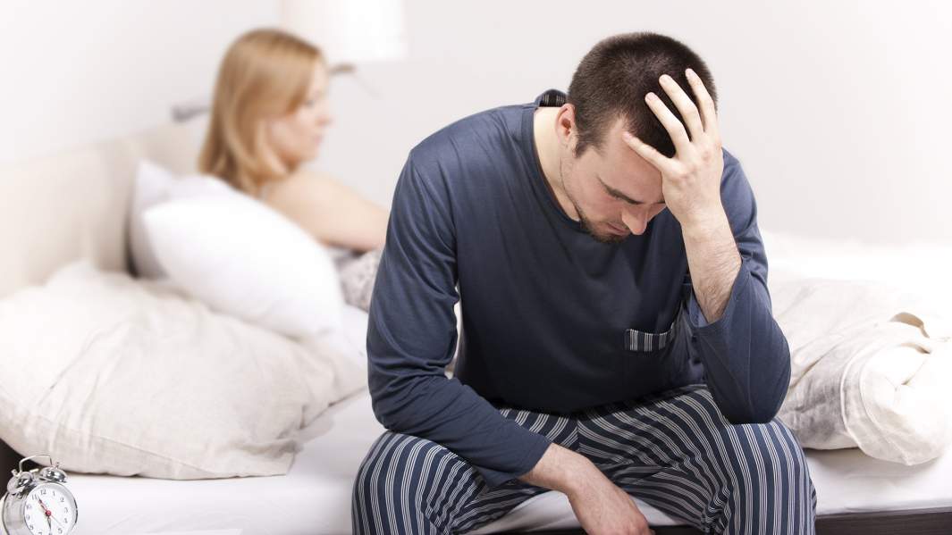 мужчина сидит на кровати 