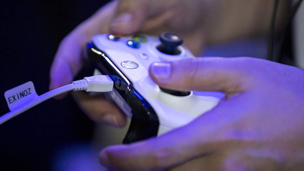 Джойстик игровой приставки Xbox в руках девушки