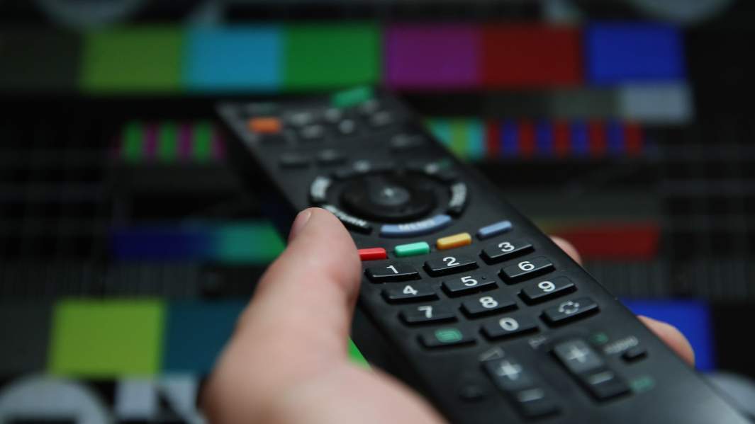 Пульт на фоне телевизора