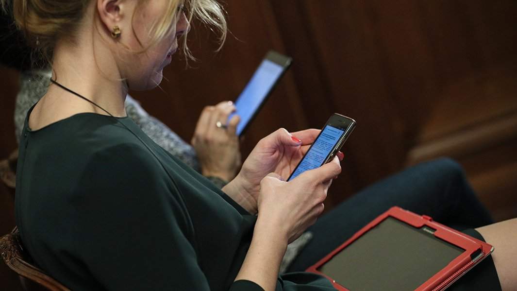 люди смотрят в свои смартфоны