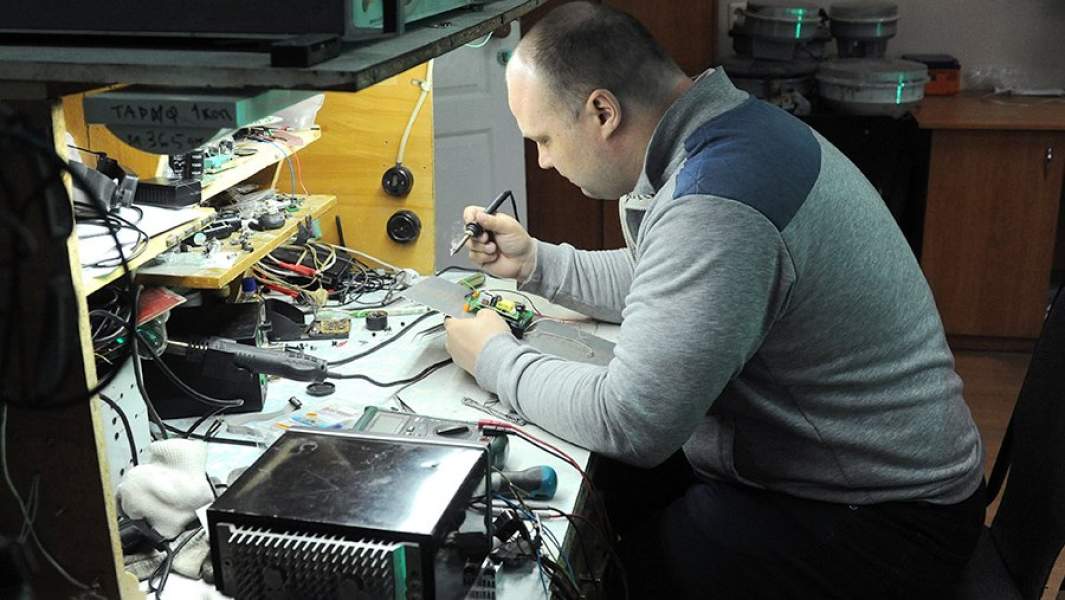 Мужчина занимается ремонтом электротехники