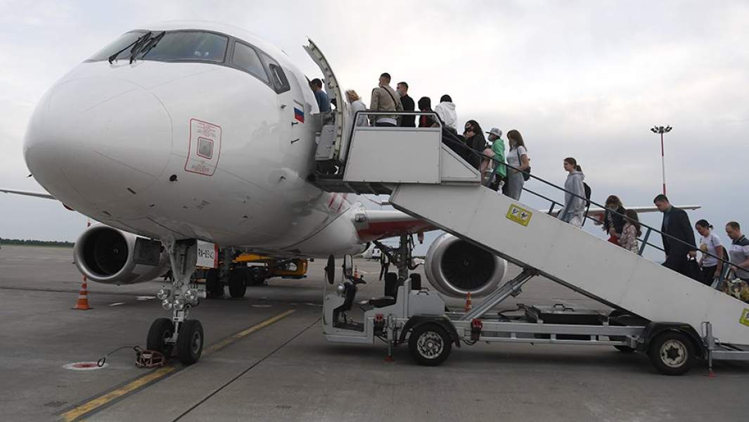 Пассажиры поднимаются по трапу на борт самолета