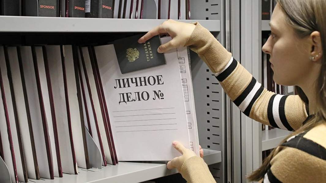 Сотрудница отдела кадров с папкой личного дела и трудовой книжкой