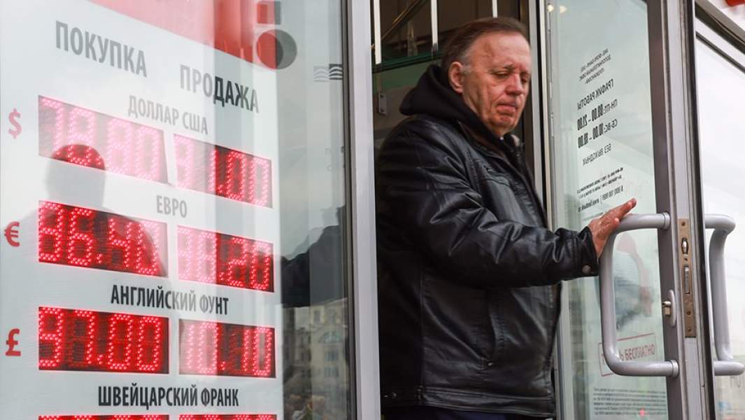 Мужчина выходит из обменника валют