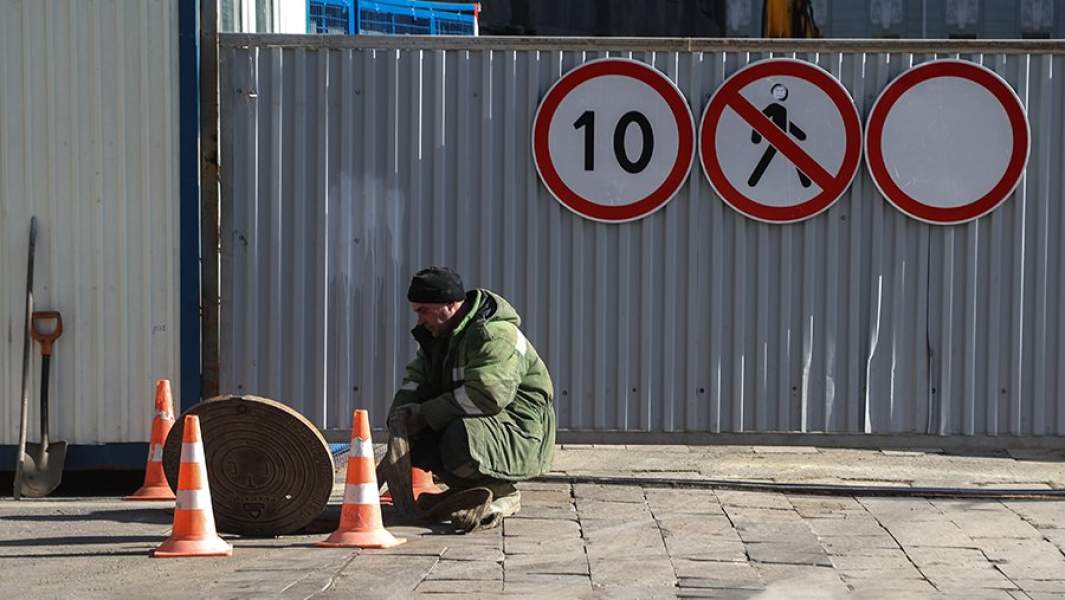 рабочий возле открытого люка