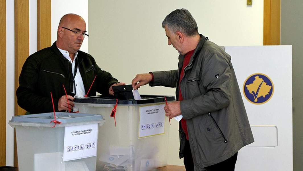 Мужчина голосует на избирательном участке во время муниципальных выборов в Косово